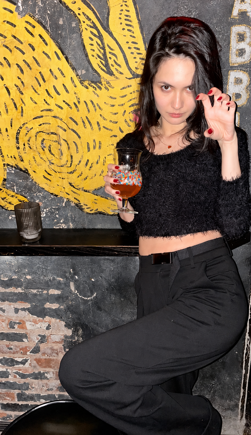 Guest with a drink beside the Old Rabbit Club mural
